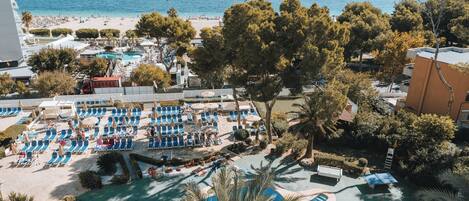 A resort with multiple swimming pools, a beach, and a view of the sea.