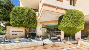 A modern building with a sign reading "apartamentos NOVA" and a glass entrance. - Globales Nova (Calvia)