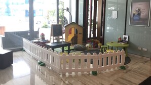 A children's play area with a white fence, playhouse, and toys. - Novotel Roma Eur (Rome)