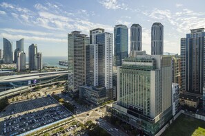 A modern hotel with a glass facade, located in a high-rise urban area with other tall buildings nearby. - Haeundae Centum Hotel (Busan)