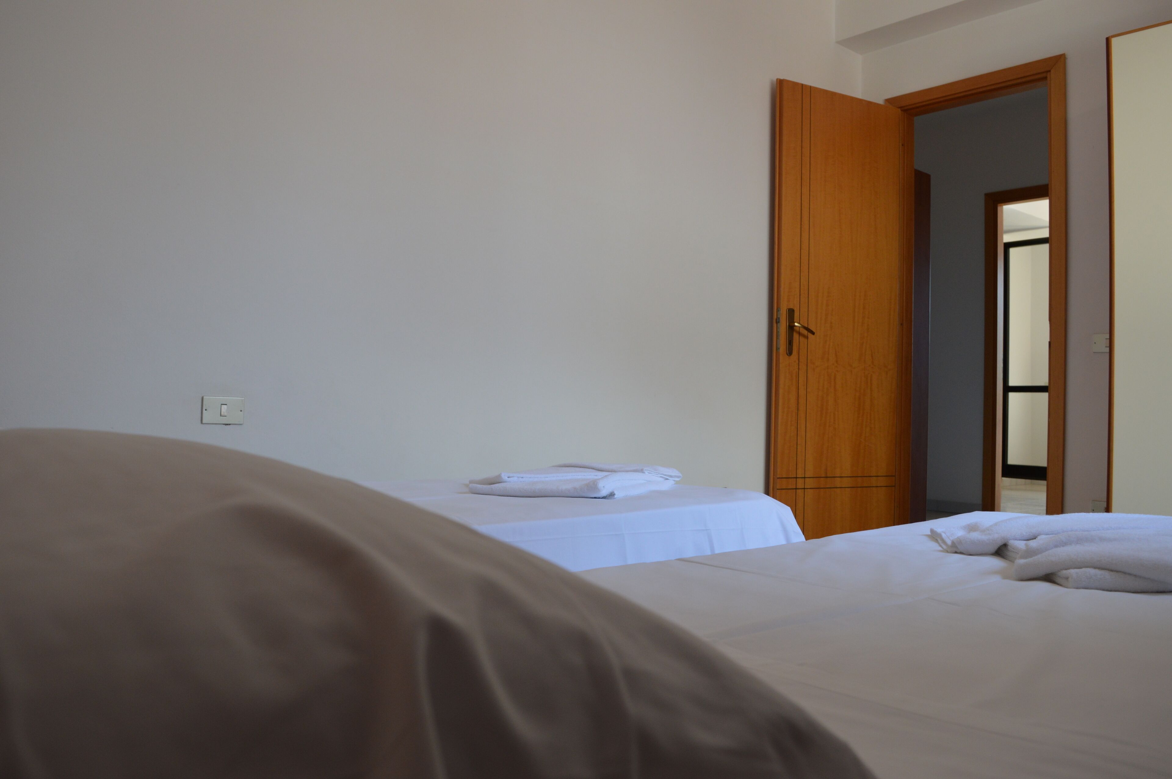 Ein Hotelzimmer mit einem Bett, einem Holzschrank und einem Spiegel an der Wand.