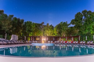 Una piscina al aire libre, sombrillas, tumbonas