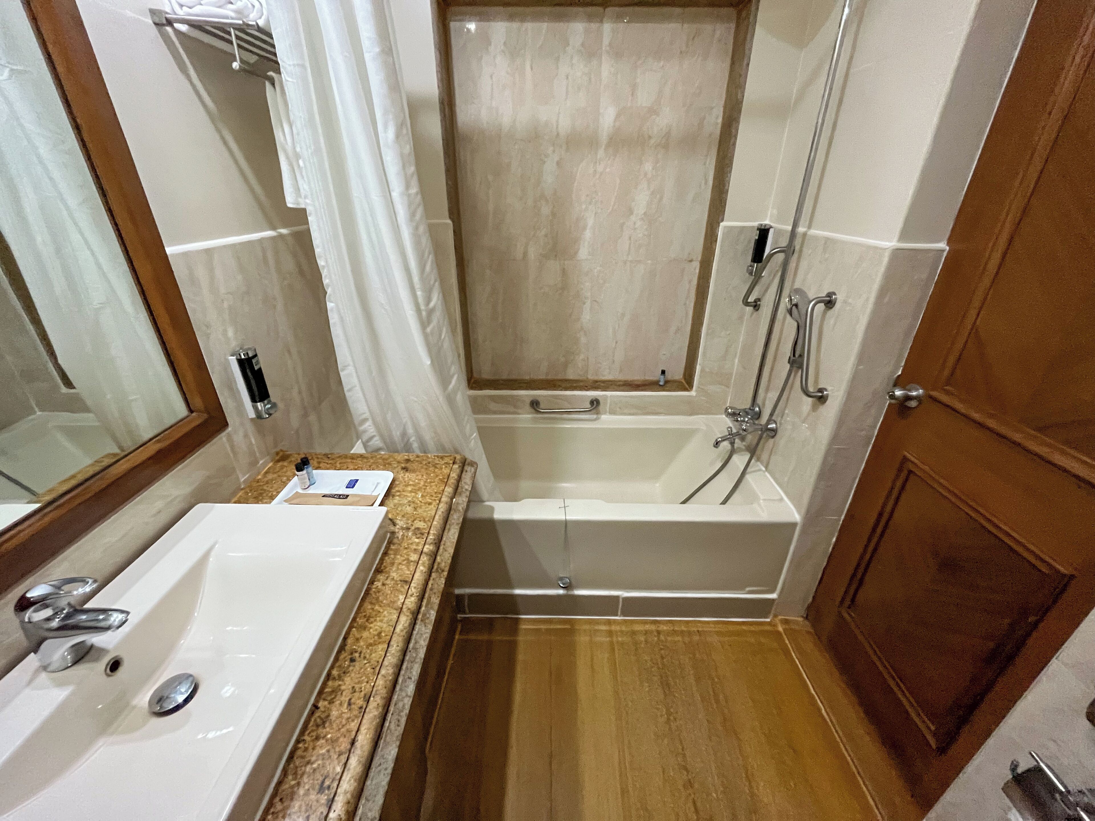 Un baño con bañera, lavamanos y zona de ducha.