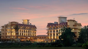 A large hotel with multiple floors, balconies, and a well-lit facade. - Acron Candolim Regina (Candolim)