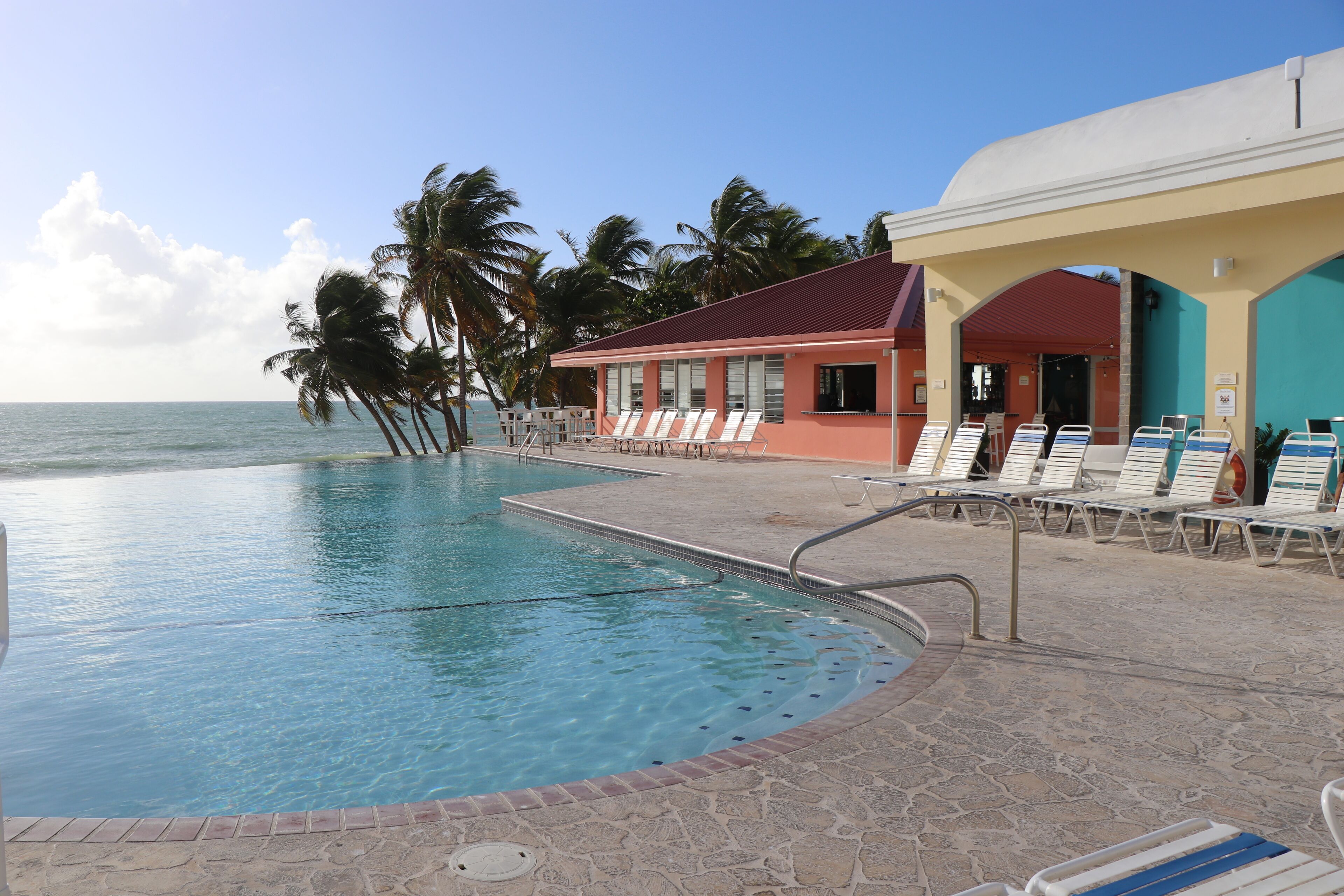 Een buitenzwembad, ligstoelen bij het zwembad