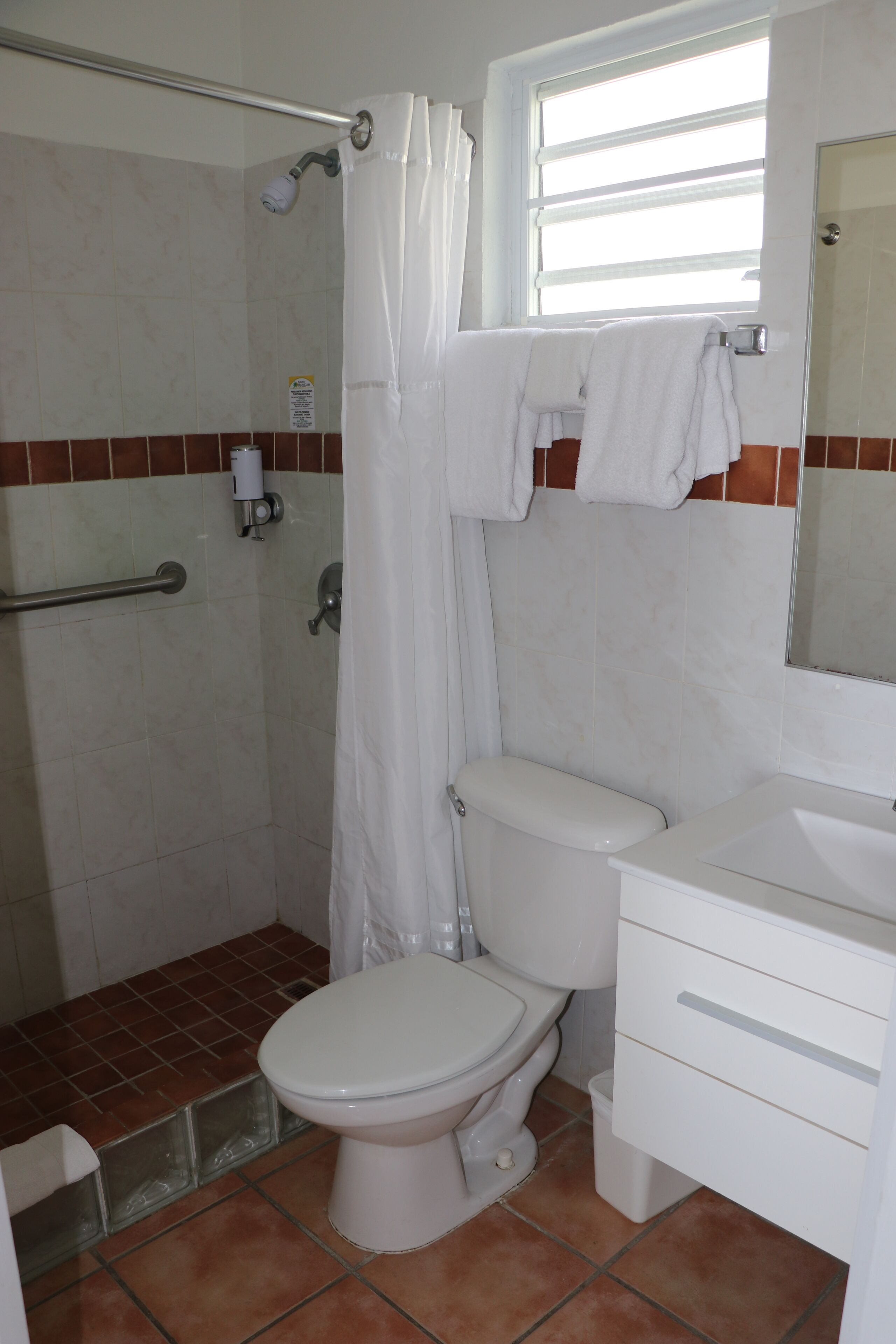 A bathroom with a shower, toilet, and sink.