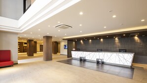 Un área de recepción moderna con mostrador, asientos y un pilar grande.
