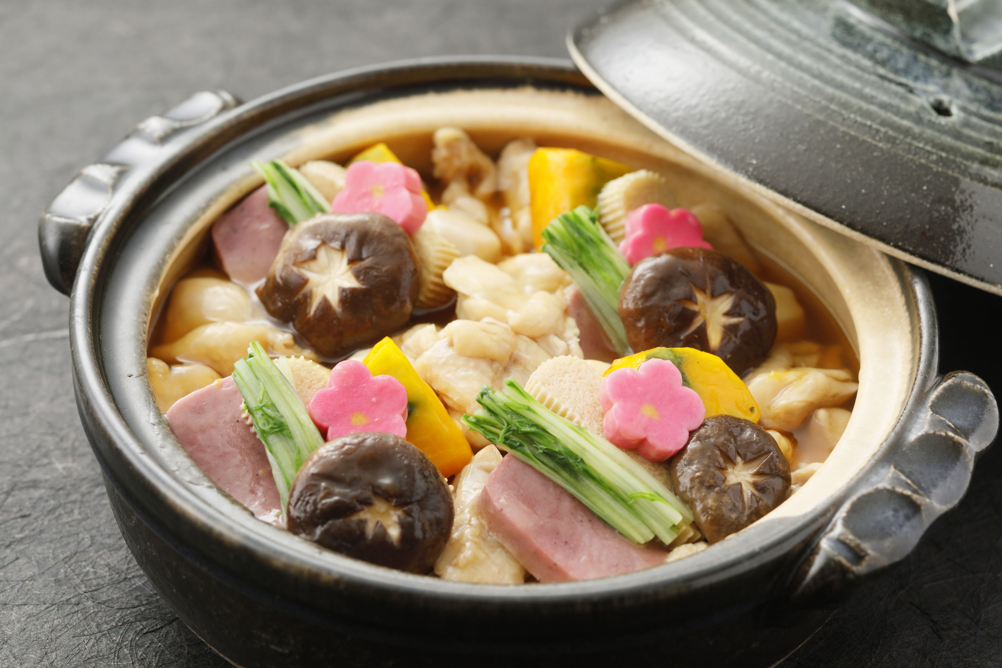 A traditional Japanese hot pot with various ingredients like mushrooms, vegetables, and meat.