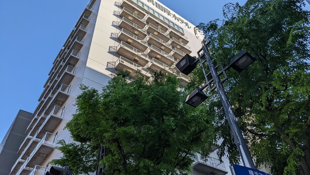 A high-rise building with multiple balconies and a clear sky.