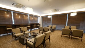 A conference room with a glass table surrounded by chairs, wooden paneling on the walls, and large windows with blinds.