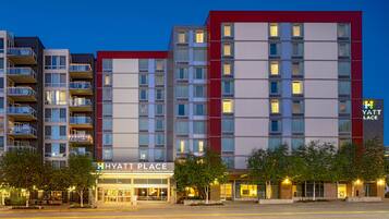 A multi-story hotel with a modern design, featuring a prominent sign for 'HYATT PLACE' and a 'YATT LACE' logo.