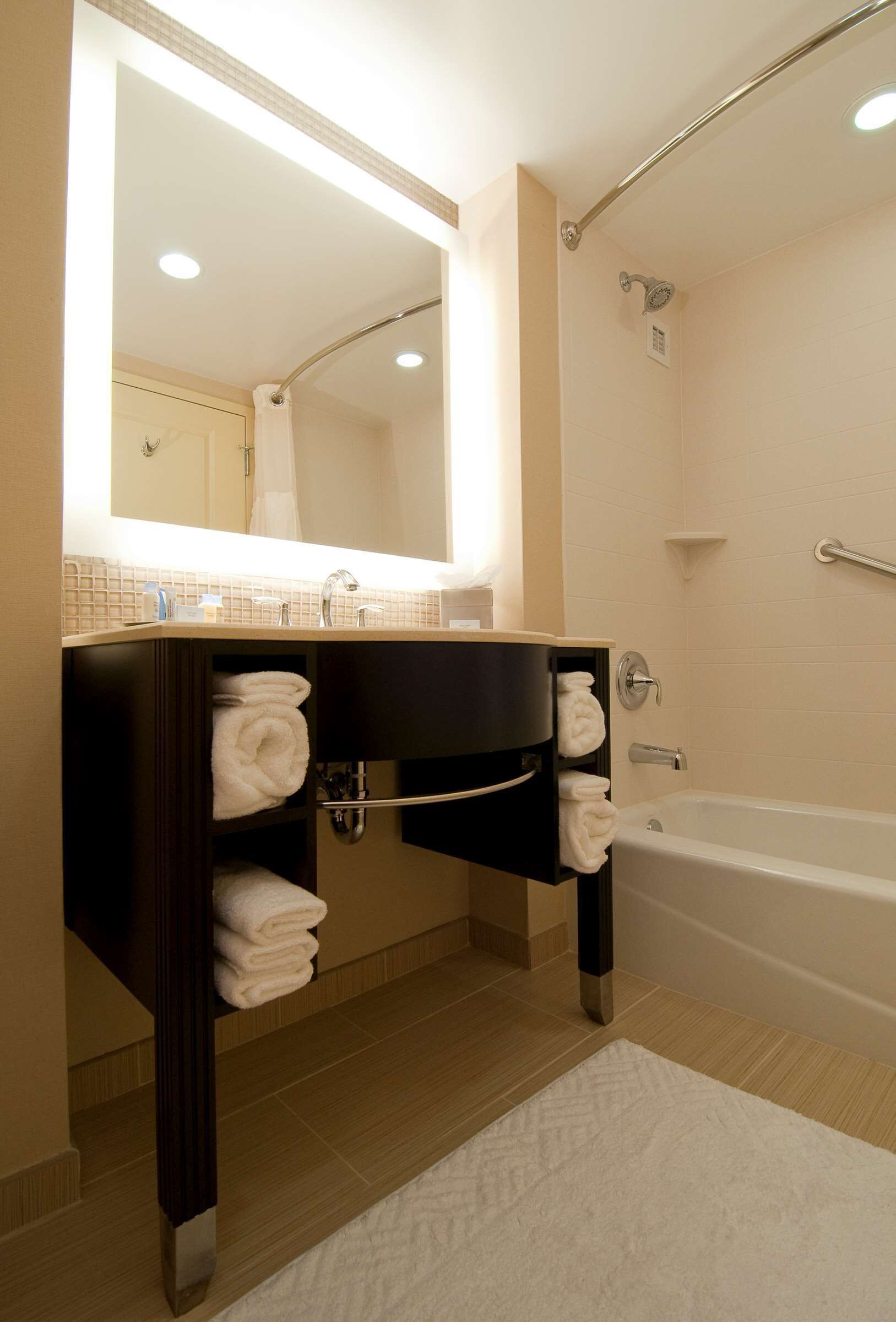 A modern bathroom with a vanity, a bathtub, and a shower.