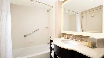 A modern bathroom with a bathtub, a sink, and a large mirror.