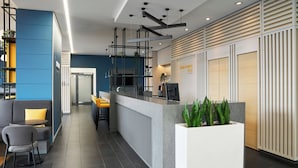 Una moderna zona de recepción con mostrador, asientos y una planta.