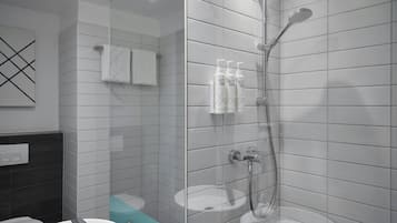 Un baño moderno con ducha envuelta en vidrio, un lavamanos blanco y un espejo.