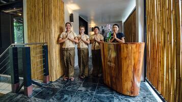 Un área de recepción con un mostrador de madera y una pared de bambú.