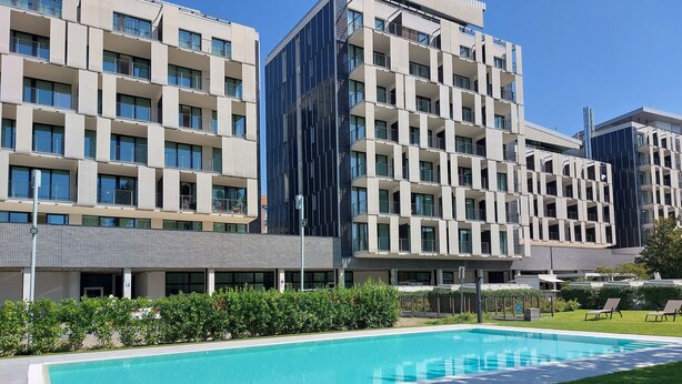 Un hôtel moderne doté d’une piscine, de pelouses bien entretenues et surplombant un ciel d’un bleu éclatant.
