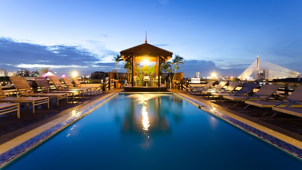 Uma área de piscina com espreguiçadeiras e um gazebo.