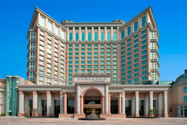 A large, multi-story hotel with a central entrance, large windows, and a fountain in front. - Four Points by Sheraton Taicang (Suzhou)