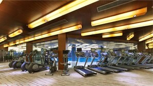 Ein Fitnessstudio mit mehreren Laufbändern, Ergometer und Crosstrainern.