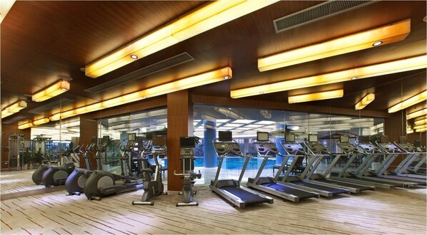 A gym with multiple treadmills, stationary bikes, and elliptical machines. - Four Points by Sheraton Taicang (Suzhou)