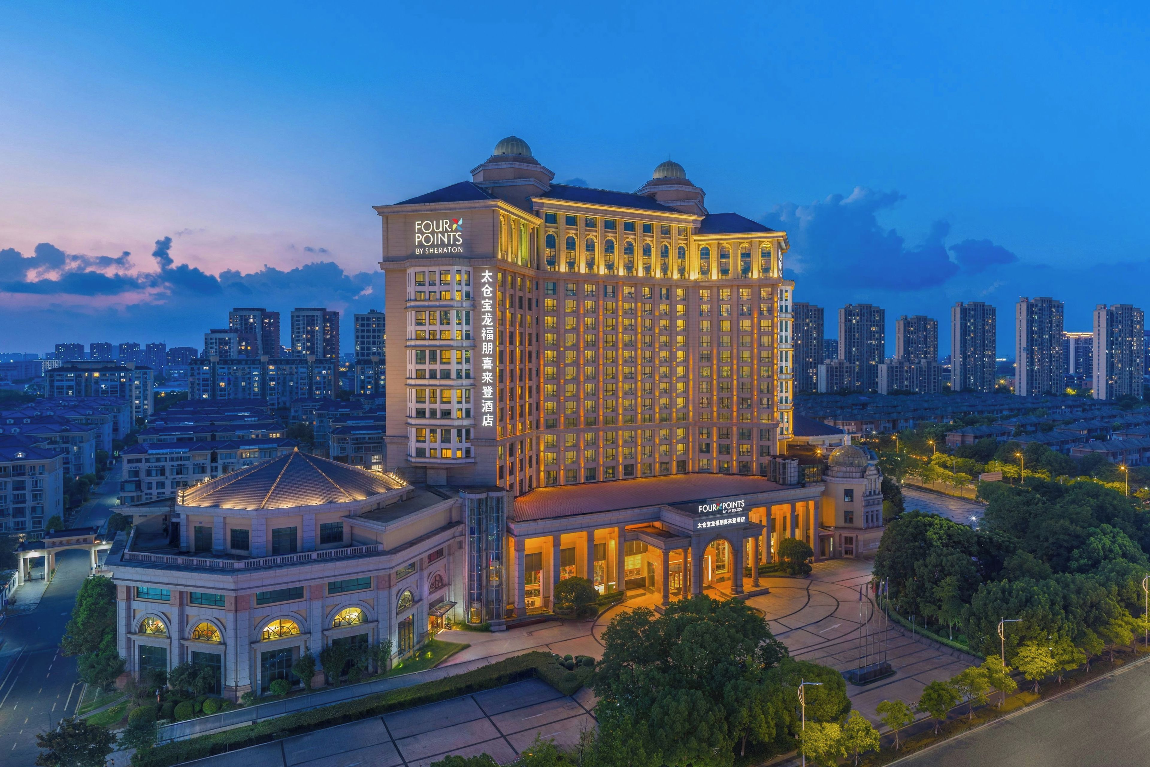 A large hotel with a classic architectural style, featuring a prominent dome and a well-lit facade.