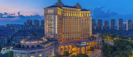 A large hotel with a classic architectural style, featuring a prominent dome and a well-lit facade.