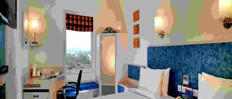 A hotel room with a bed, a desk, a chair, a minibar, and a window with a view of the city.