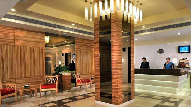 A hotel lobby with wooden paneling, a reception desk, and a check-in counter. - Hometel Chandigarh (Chandigarh)