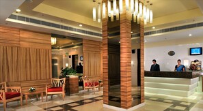 A hotel lobby with wooden paneling, a reception desk, and a check-in counter. - Hometel Chandigarh (Chandigarh)