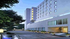 A modern hotel with a prominent sign, large windows, and a well-lit entrance. - Hometel Chandigarh (Chandigarh)
