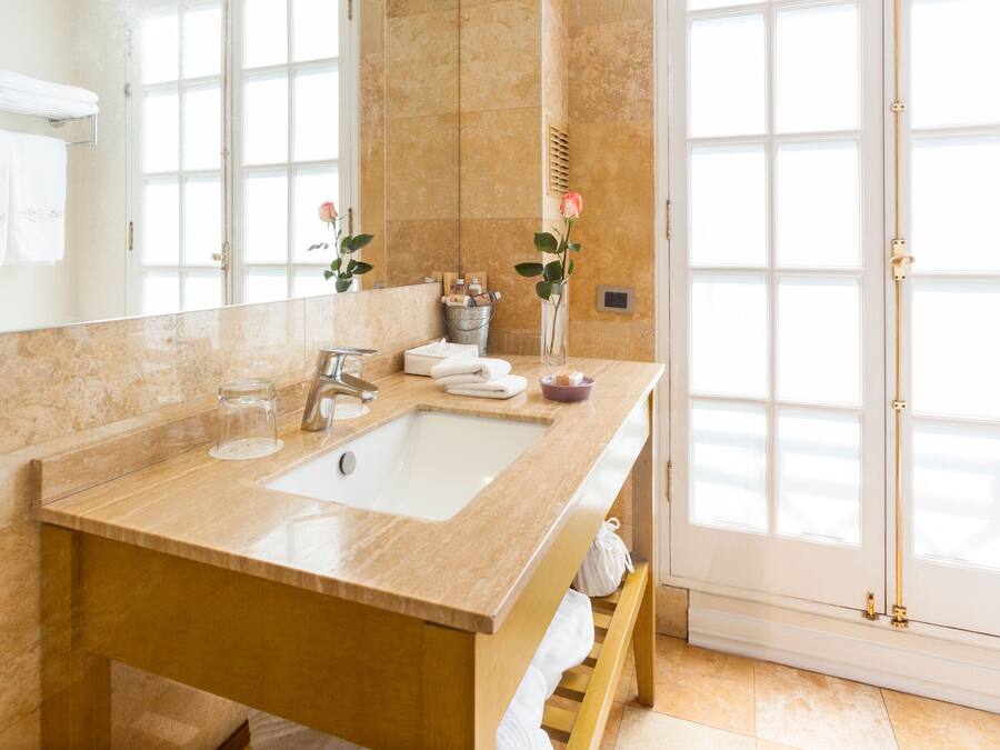 A bathroom with a large sink, a mirror, and a shower area.
