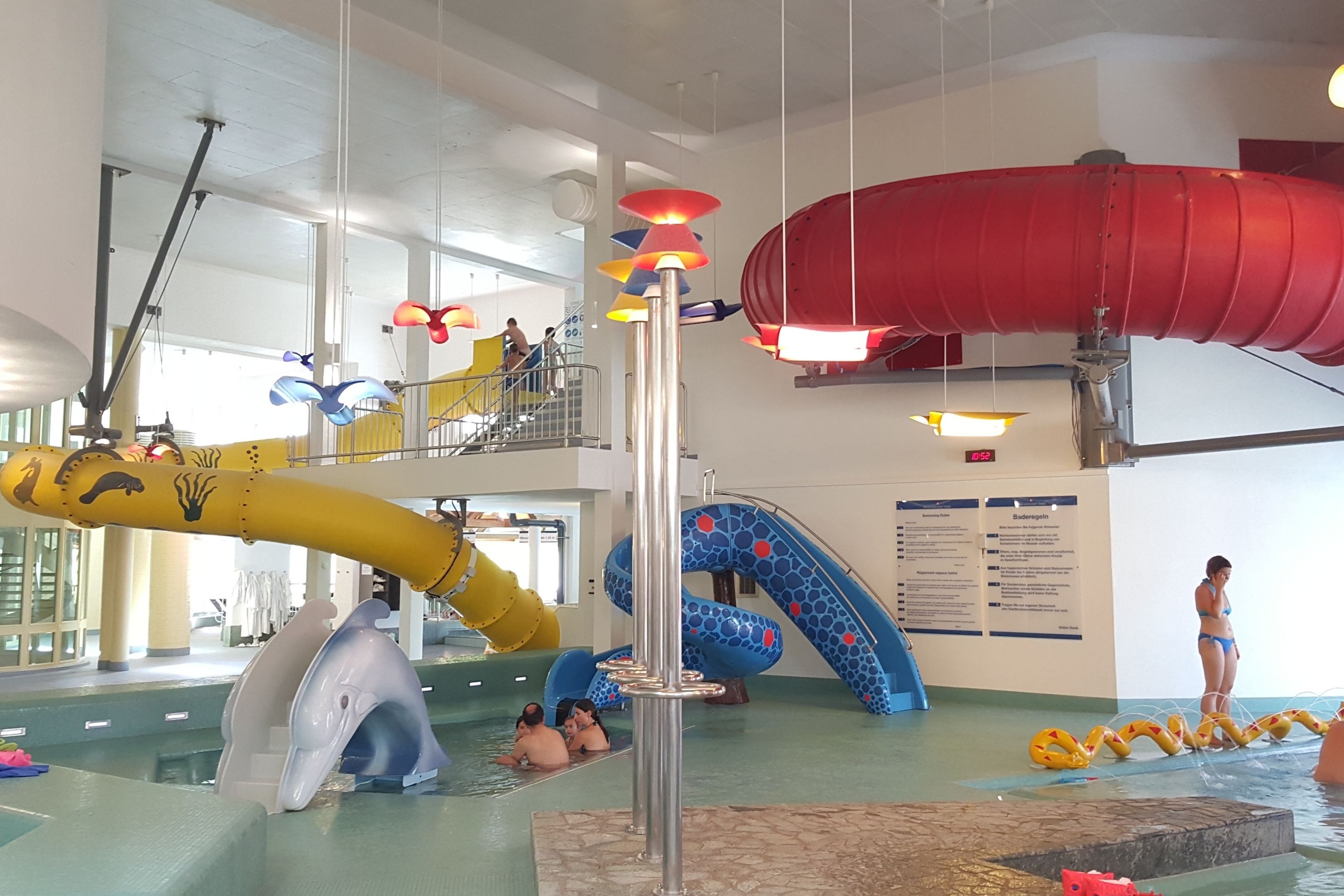 An indoor water park with slides, a pool, and a lifeguard stand.