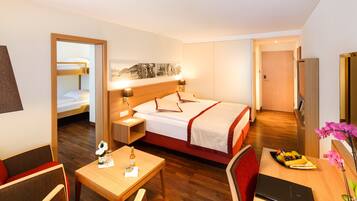 Ein Hotelzimmer mit Bett, Nachttisch, Lampe und Schreibtisch mit Stuhl.