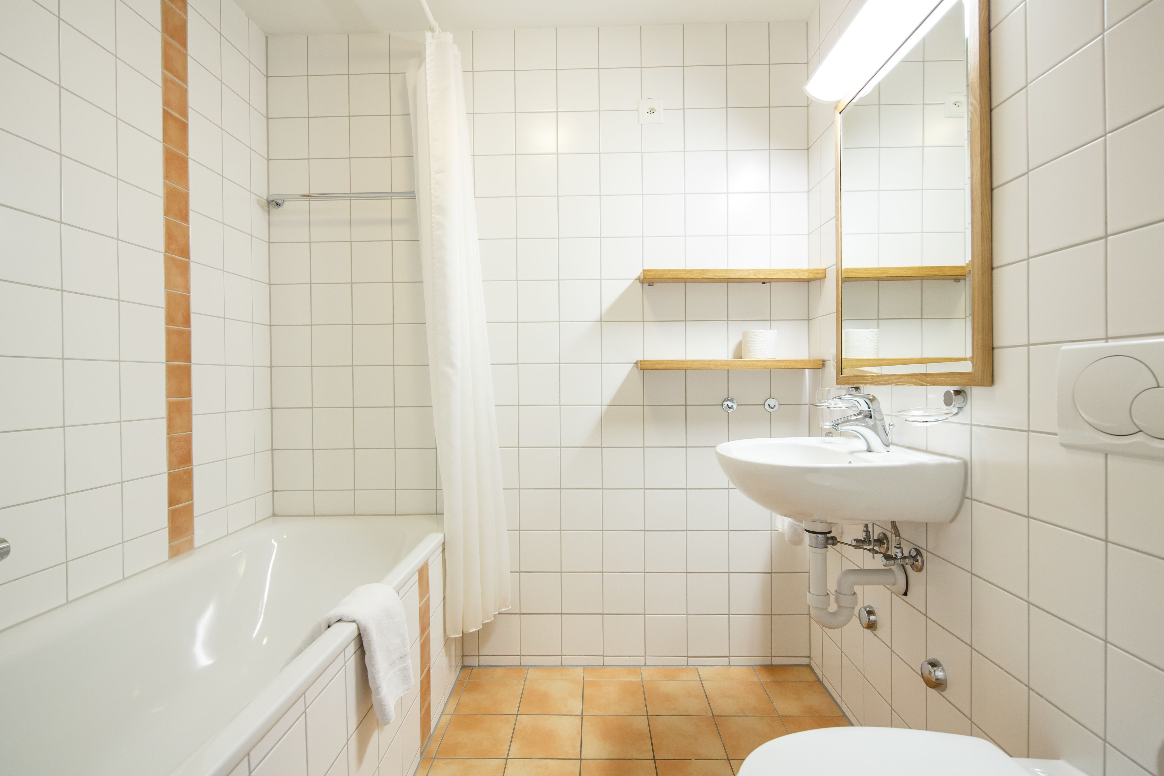 Un baño con bañera, inodoro, lavabo y cortina de ducha.