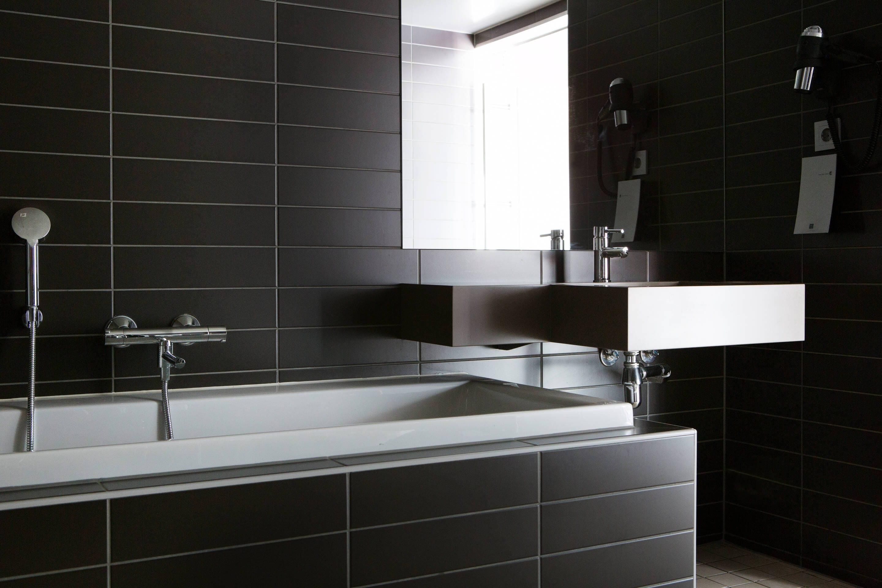 A modern bathroom with a large bathtub, a separate shower area, and a vanity with a mirror.