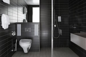 Un baño moderno con inodoro, ducha y lavamanos.