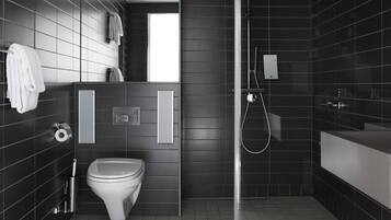 Une salle de bain moderne équipée de toilettes, d’un lavabo et d’une douche.