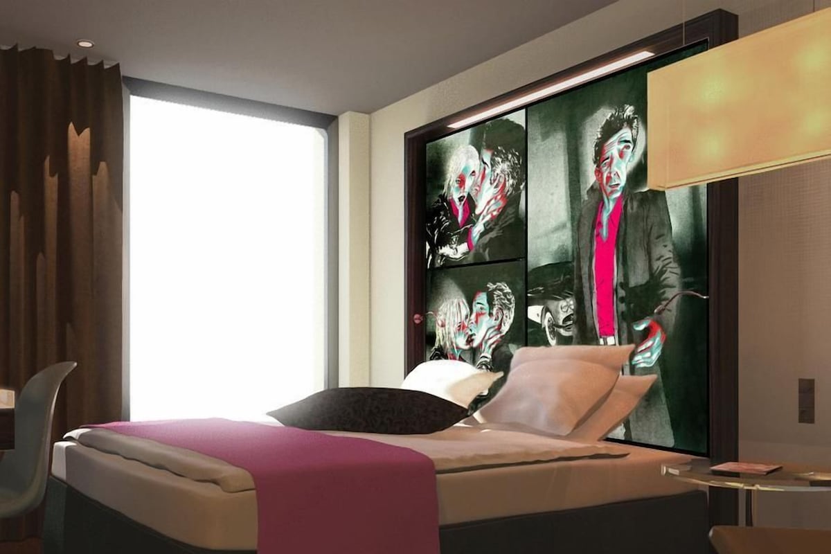 Una habitación de hotel moderna con una cama grande, un escritorio y una ventana con cortinas.