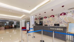 A hotel reception area with a reception desk, blue rope barrier, and modern pendant lighting. - Days Inn Guangzhou (Guangzhou)