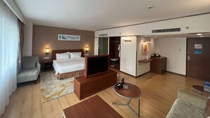 A hotel room with a bed, a TV, a desk, a chair, and a small table. - Days Inn Guangzhou (Guangzhou)