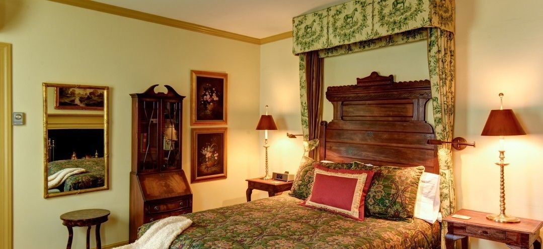 A traditional bedroom with a wooden bed, two bedside tables, and a mirror.