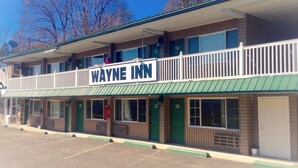 A two-story motel with a green awning and a balcony on the upper floor. - Wayne Inn (Honesdale)