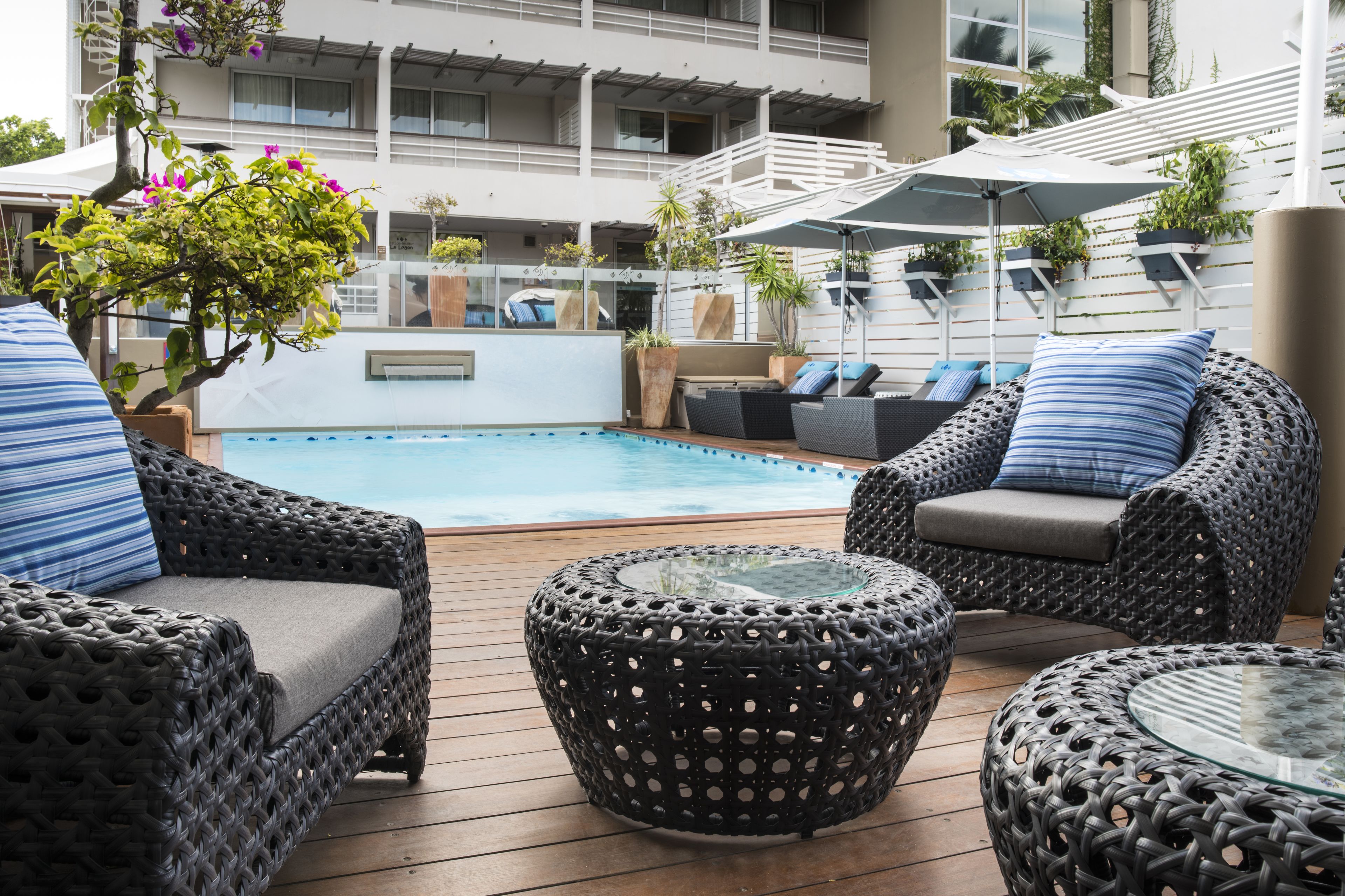 Een buitenzwembad, parasols bij het zwembad en ligstoelen