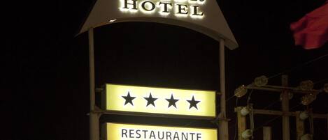 A hotel sign with a star rating and mentions a restaurant and games.