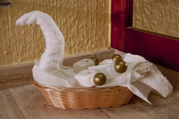 A wicker basket with toiletries and a white towel on a marble floor. - Hotel Los Andes (Coatzacoalcos)