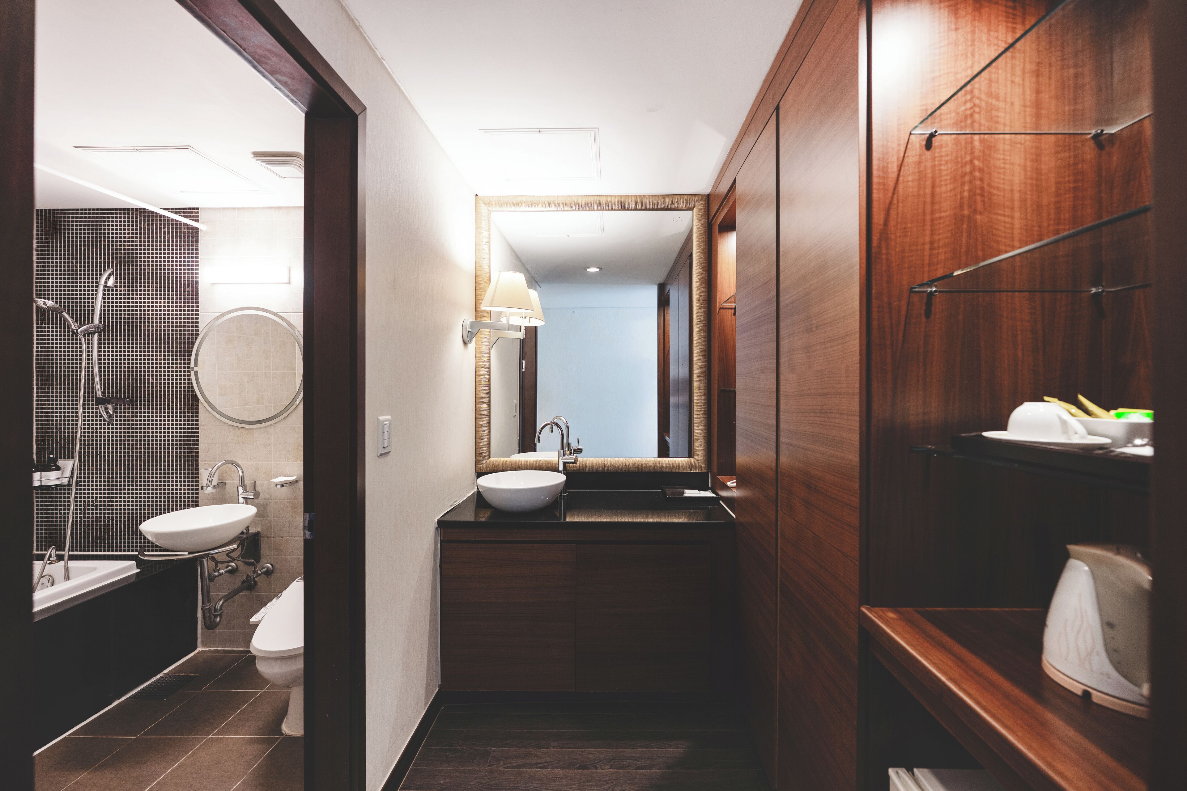 Une salle de bain moderne avec un lavabo, un miroir et un porte-serviettes.