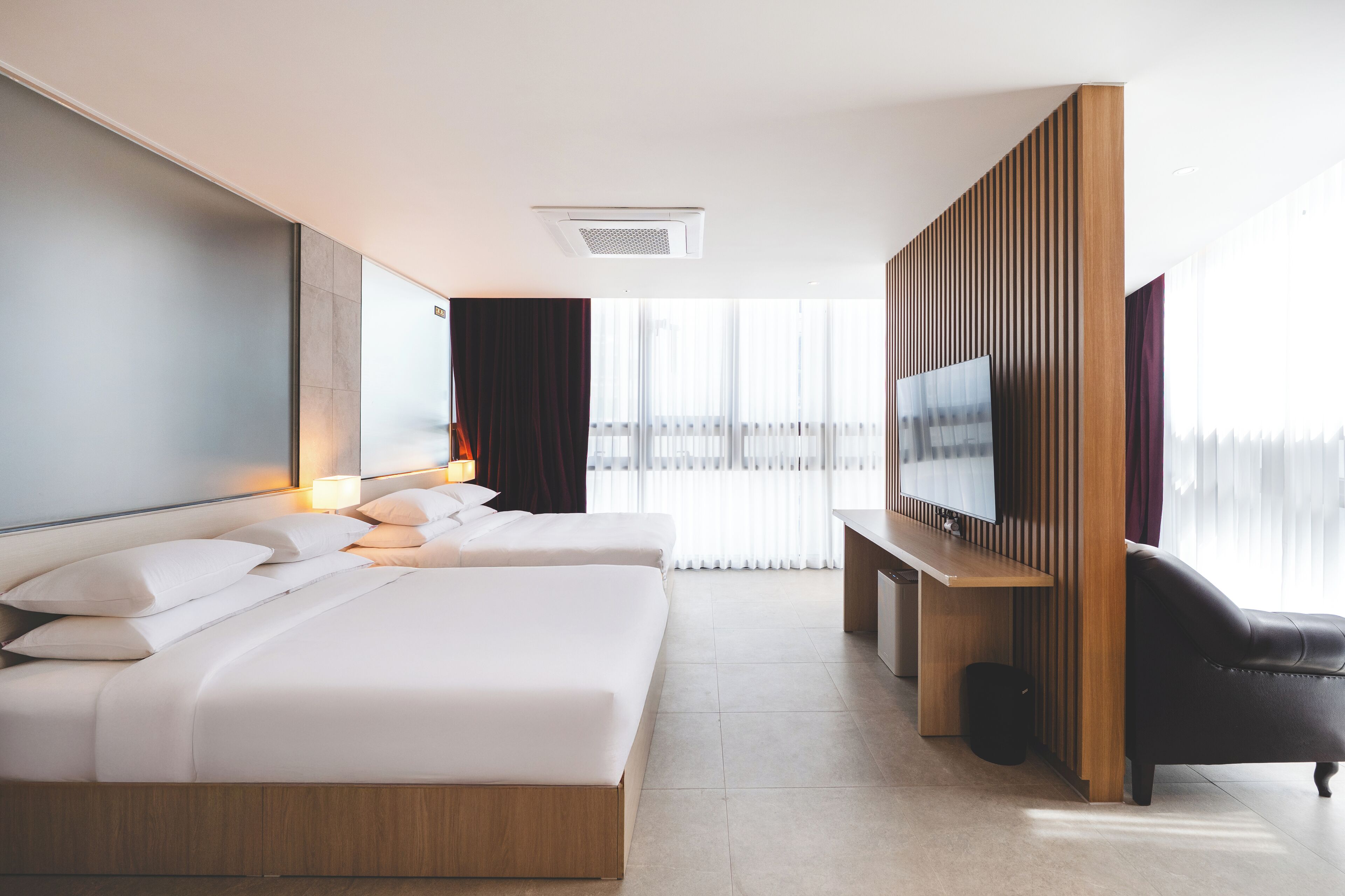 Habitación de hotel con una cama grande, televisión, escritorio y una silla.