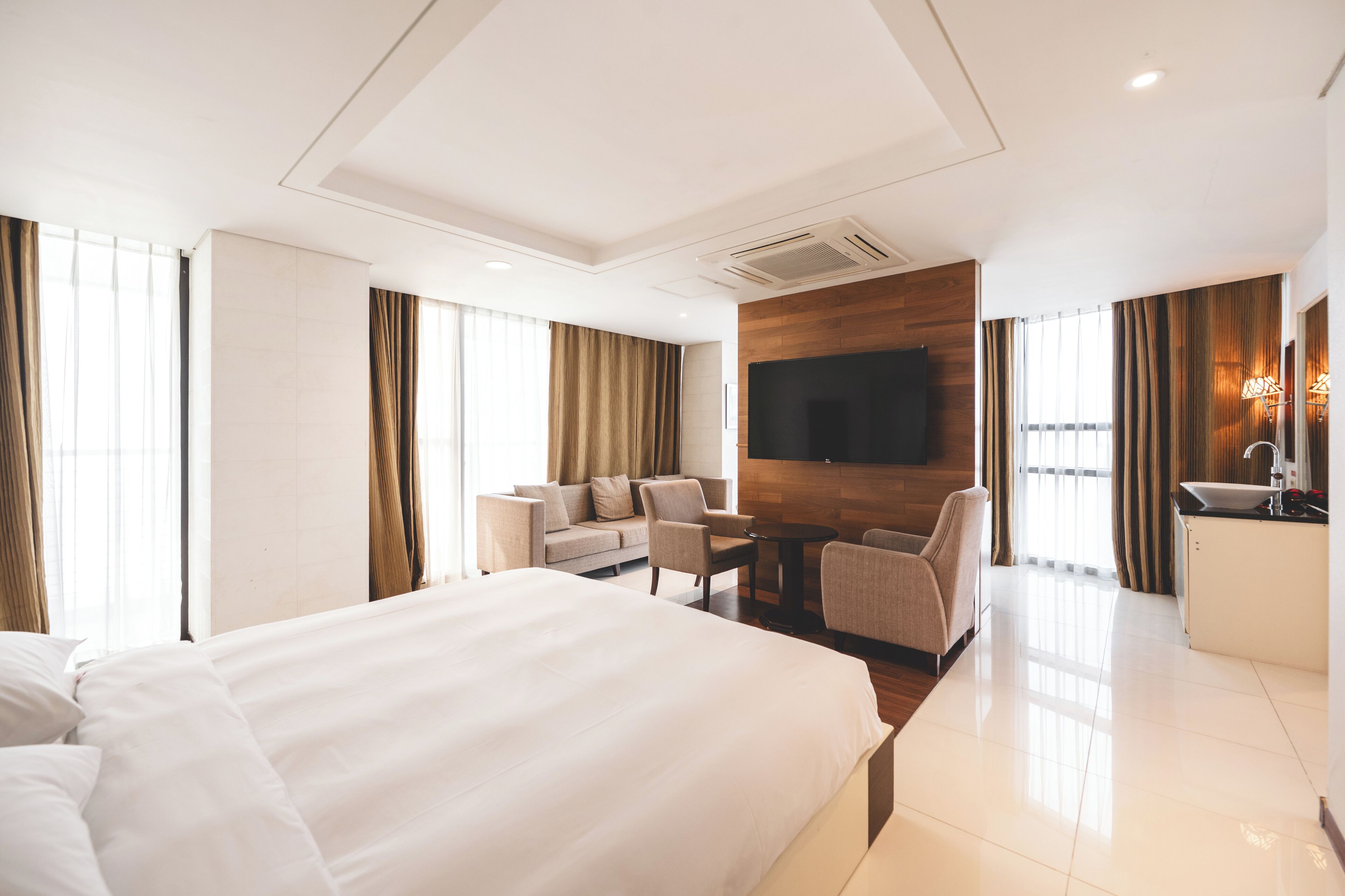 Een hotelkamer met een groot bed, een bank, een bureau en een televisie.