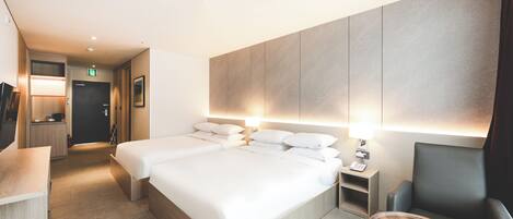 Una habitación de hotel con una cama grande, mesitas de noche, un escritorio y una silla.